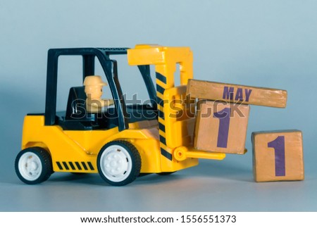 may 11th. Day 11 of month,  Construction or warehouse calendar. Yellow toy forklift load wood cubes with date. Work planning and time management. spring month, day of the year concept.
