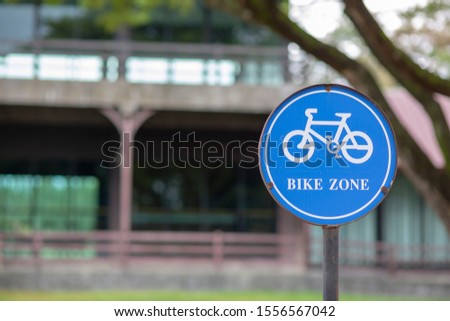 The blue circle sign has a picture of a bicycle, meaning it is a sign for a bike ride or a bike zone.