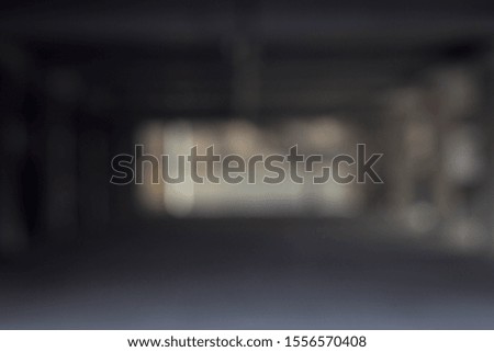 Out of focus parking garage with cars and trucks parked in all of the parking spaces