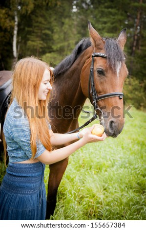 girl feeds a horse an apple