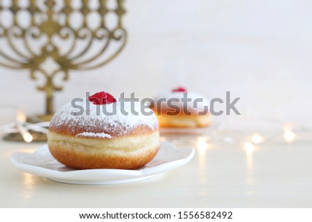 religion image of jewish holiday Hanukkah with doughnut over white background