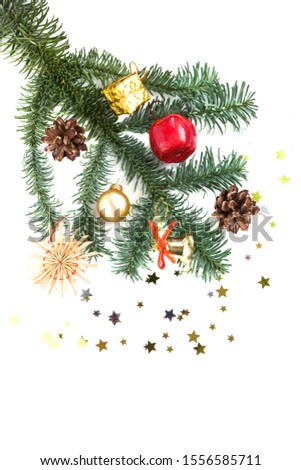 Christmas decorations and tree branch on white background. Cones, red apple, golden bell, present, ball and confetti. Flat lay. New Year and Christmas mood