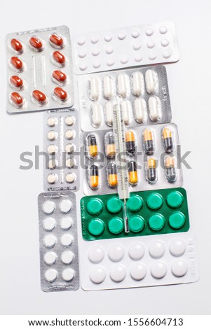 Pills for the treatment of different colors and a thermometer for measuring body temperature