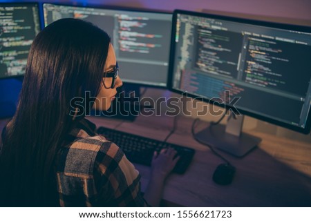 Photo of serious confident focused girl concentrated on hacking the security code of her opponents in spectacles using java script