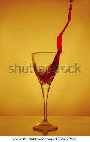 Splashes of dry red wine frozen in flight on a yellow background