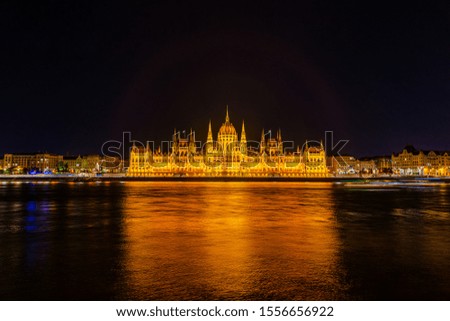 Illuminated historical building of Hungarian Parliament at night on Danube River Embankment