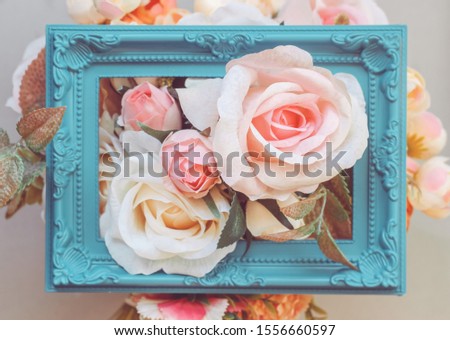 Composition made of photo frame and artificial flowers in pastel colors