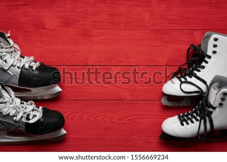 Winter holidays activity concept. Top view of woman and man skates on red planks