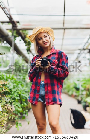 Beautiful female photographer posing with mirrorless camera.