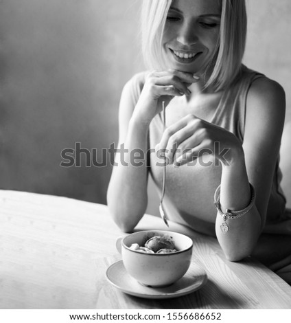 woman with ice cream at a table in a cafe, black and white photo