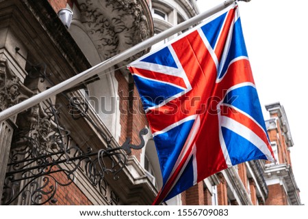 Union Jack waving in wind in front of british house facade