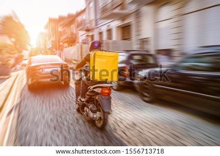 Fast and free delivery food by scooter in the afternoon in the city  Royalty-Free Stock Photo #1556713718