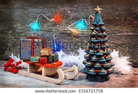 creative image Christmas tree and gift boxes sleigh with gifts on an old wooden surface, place for text, retro style