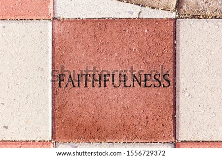 The word of faithfulness engraved on a sidewalk paver