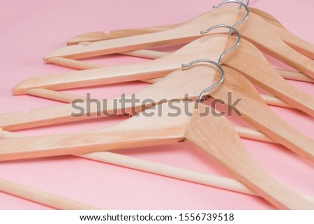wooden empty clothes hangers on a pink background. concept: pop modern sale