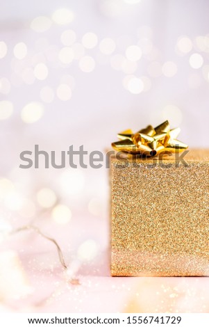 Close up of Xmas golden present box, Christmas postcard concept, feminine pink background, copyspace