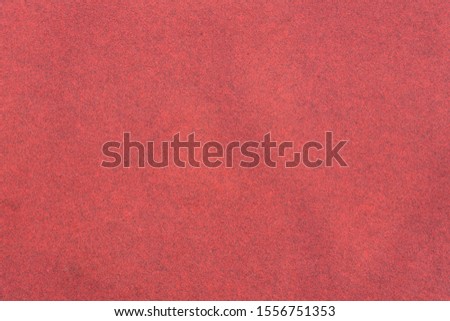 Red background, terry heavy texture. Empty fabric backdrop with dark patches. Floor covering red carpet textile.