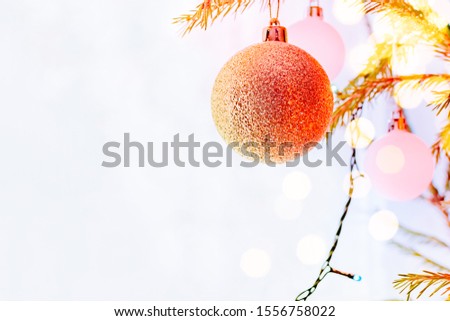 Holiday border with hanging christmas tree ball decorations on a light background