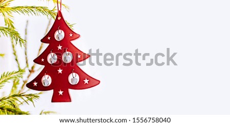 Holiday border with hanging christmas tree bauble decorations on a light background
