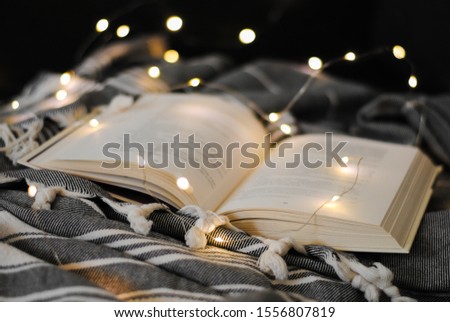 An open book is lying on the bed. Holiday cozy atmosphere.
