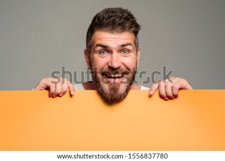 Happy man showing blank board with copy space. Advertisement. Smiling man hold empty placard. Businessman with blank poster. Bearded man holds blank billboard. Attractive guy holds advertising banner