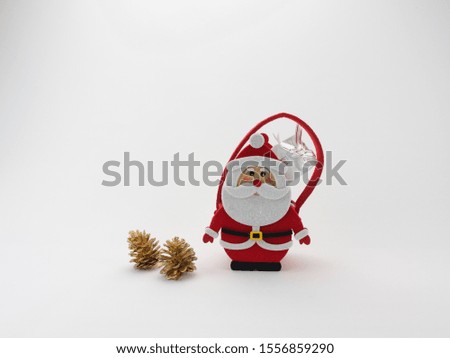 Santa with a basket on the back and a gift on a white background, next to gold cones and a Christmas tree. Photo on the front