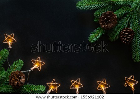 Holiday Christmas card background with festive decoration ball, stars, snowflakes, gift box, pine cones on a black background from Flat lay, top view. Space for text Merry Christmas and happy New Year