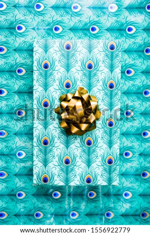 Christmas package composition, the package with a golden ribbon over the same paper who wraps the gift, top view, christmas shopping theme and conceptual image for holiday