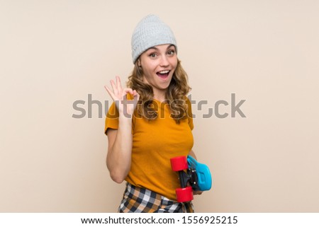 Young skater blonde girl making OK sign over isolated background