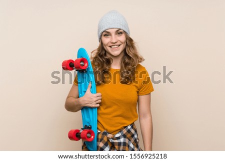 Young skater blonde girl over isolated background smiling a lot