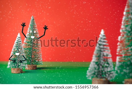 christams tree with smile face emotion doodle style decoration on green table with vivid red background.holiday celebration greeting card with copy space