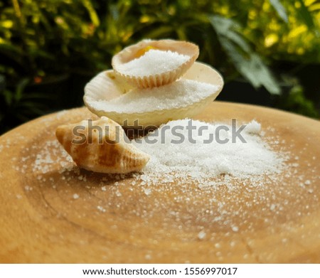 Sea salt spread out from the shells on the wooden floor. Royalty-Free Stock Photo #1556997017