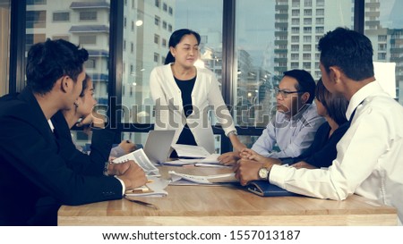 Asian business people discuss marketing strategy in group meeting at modern office. Business finance and teamwork concept.