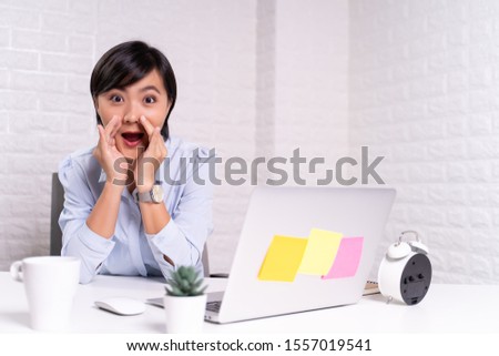 Woman sitting at home office using computer laptop and saying secret news