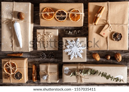 Creatively wrapped and decorated christmas presents in boxes on dark wooden background, flat lay, top view