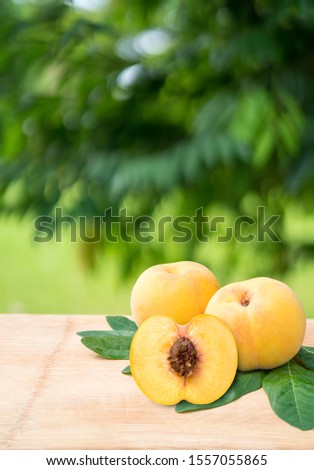 Honey Yellow Peach on the old wooden table,Fresh Korean peaches on wooden plate in wooden Background,Yellow Peaches in blur background