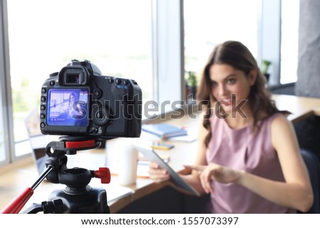 Beautiful young woman talking and smiling while making new video for her blog.