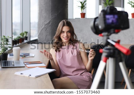Beautiful young woman talking and smiling while making new video for her blog.