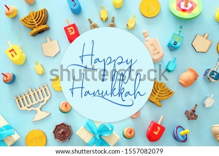 religion image of jewish holiday Hanukkah background with menorah (traditional candelabra), spinning top over wooden blue background. top view, flat lay