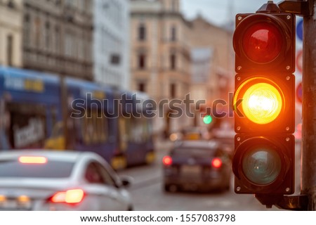 A city crossing with a semaphore. Orange light in semaphore - image