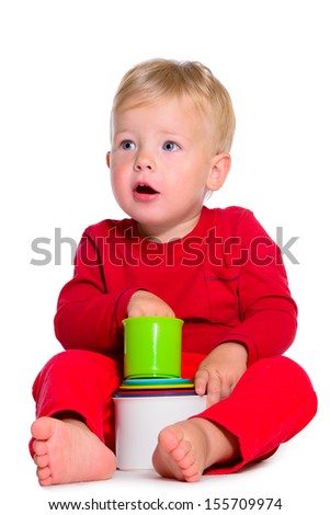 portrait of cute little caucasian baby sitting with toys. isolated on white background. baby 1 year