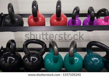 multi-colored kettlebells in the gym, the concept of sports and physical activity