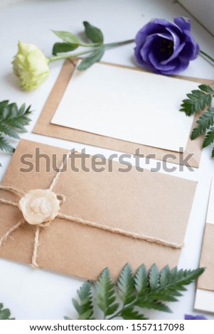 Flat lay wedding invitation, close-up cards with ribbons, eustoma and leaves. card mockup. gift box with present.  sealing wax.