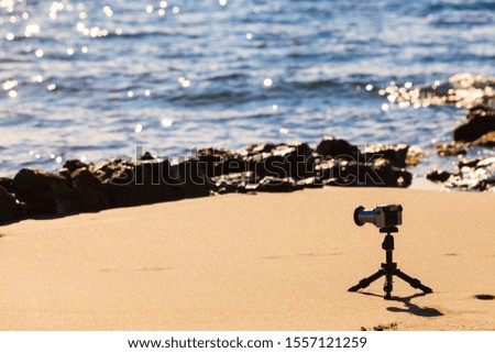 Camera on little tripod taking film video or shooting images pictures of sea coastline in Greece Peloponnese