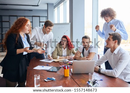 Caucasian young team of businesspersons involved in creative business discussing work in the office and they in shock look at each other , office background