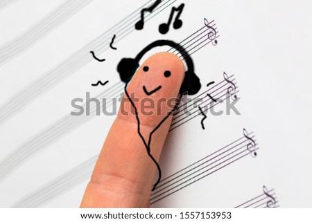 concept. finger lies on notes and listens to music. he is satisfied