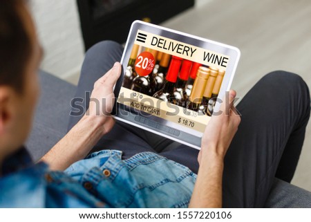Hipster man hands holding digital tablet with app delivery food wine screen