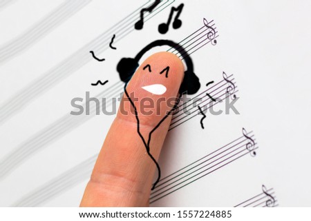concept. finger lies on notes and listens to music. he is satisfied