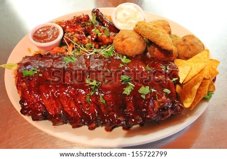 ribs back baby barbecue Tex mex BBQ ribs and wings platter with nachos tortilla stock photo, stock, photograph, image, picture 