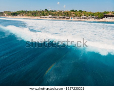 Blue barrel wave in ocean and beach at background. Aerial view of barrel waves